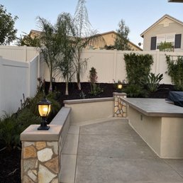 Back yard: Retaining wall, pillars with lights.