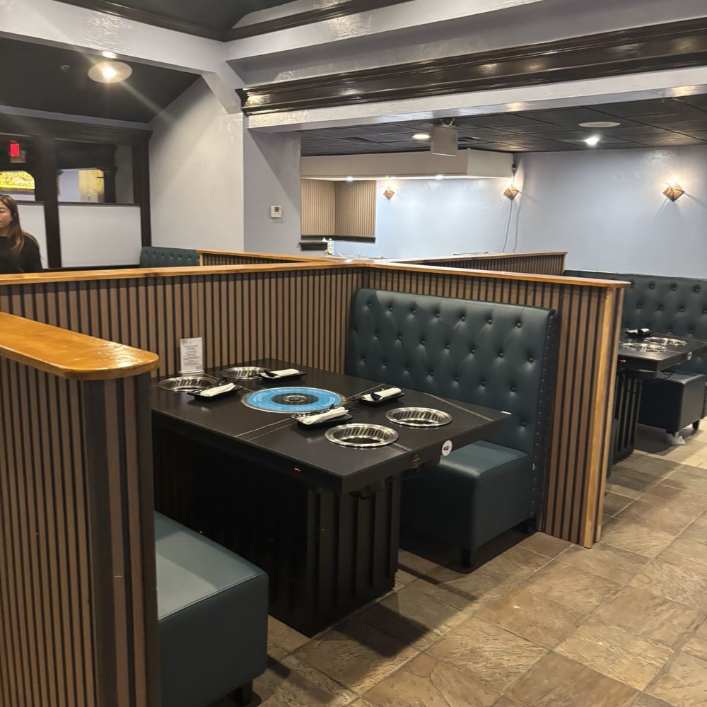 Table booths with built-in heaters for individual hot pots and a central grill for Korean barbecue Table booths with built-in heaters for individual hot pots and a central grill for Korean barbecue