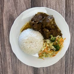 Jam-Rock Cuisine - Curry goat with white rice and steamed vegetables