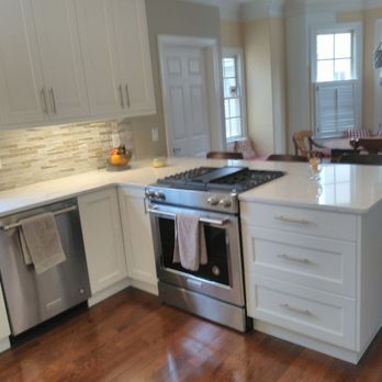 LJ Trimworks - a kitchen with white cabinets and stainless steel appliances - General Contractors Near Me