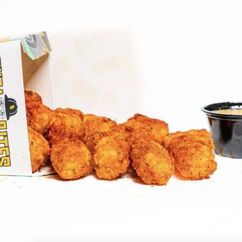 Tyga Bites - a box of chicken nuggies next to a bowl of dipping sauce - Comfort Food Near Me Tyga Bites - a box of chicken nuggies next to a bowl of dipping sauce - Comfort Food Near Me
