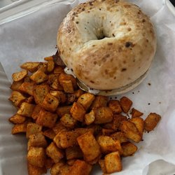 Bacon and egg on an onion bagel with the best home fries!