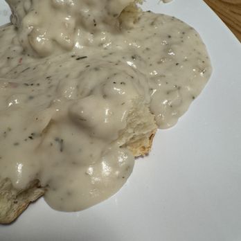 Darbi's Cafe - Slices of bread are topped with a thick, creamy gravy containing black pepper and herbs, served on a white plate. - American Near Me - Pinetop, Arizona