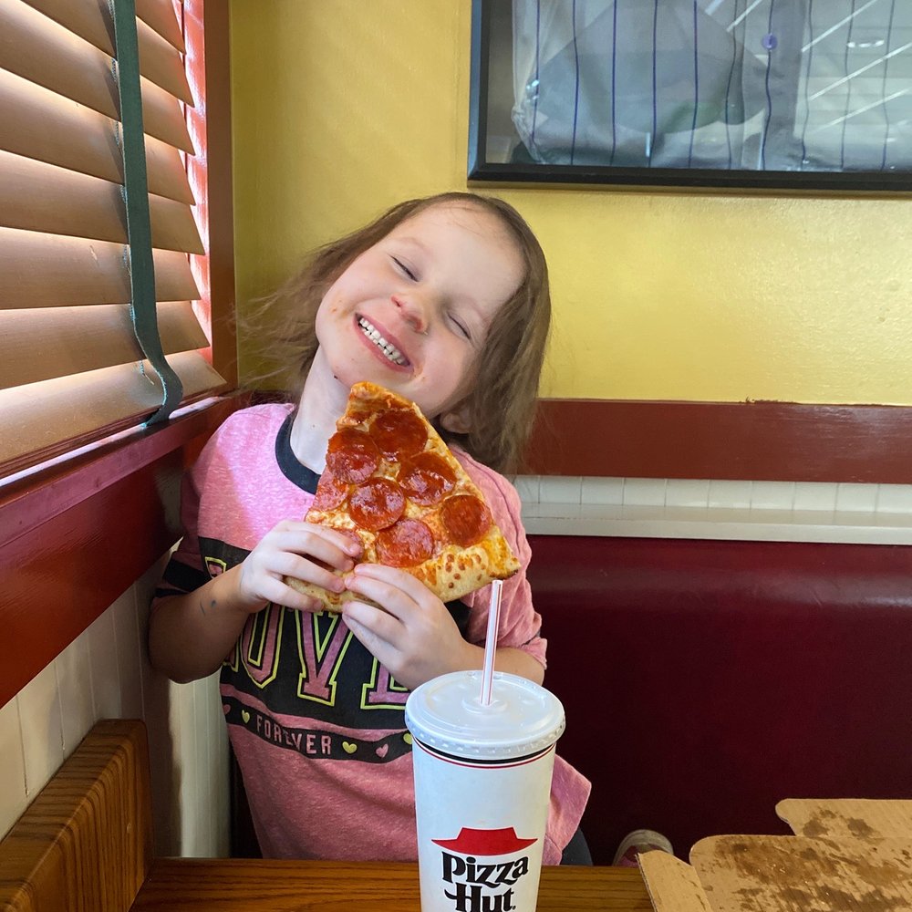 a little girl eating a slice of pizza a little girl eating a slice of pizza