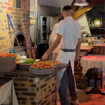 Pizzeria Da Paolo - Preparing pizzas in the brick oven at the heart of the restaurant - Pizza Near Me - Geneva, GE Pizzeria Da Paolo - Preparing pizzas in the brick oven at the heart of the restaurant - Pizza Near Me - Geneva, GE