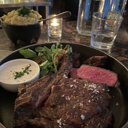29 ounce Mission Cut Ribeye Steak served with horseradish sauce and mashed potatoes in the background. Steak medium rare. 29 ounce Mission Cut Ribeye Steak served with horseradish sauce and mashed potatoes in the background. Steak medium rare.