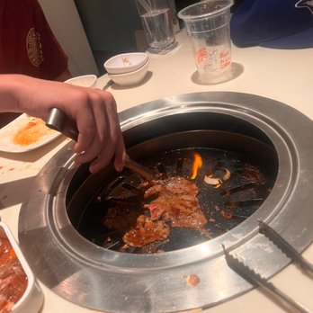 Korean Grill House - a person stirring up a hot pot - Korean Near Me - Toronto, Ontario Korean Grill House - a person stirring up a hot pot - Korean Near Me - Toronto, Ontario