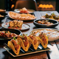 AMAN Tandoor & Bar - Unsere Keema Tacos - gefüllt mit fein gewürztem Lammhack, sonnengereiften Tomaten, roten Zwiebeln, schmelzendem Chedda, Aman-Sauce.