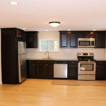 CS Mass Construction - a kitchen with black cabinets and stainless steel appliances - General Contractors Near Me - Hingham, Massachusetts CS Mass Construction - a kitchen with black cabinets and stainless steel appliances - General Contractors Near Me - Hingham, Massachusetts