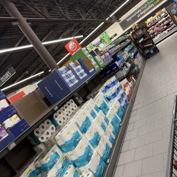 ALDI - Household items - A supermarket aisle displays various household paper products, including toilet paper and paper towels, with signage indicating high quality and low prices. - Grocery Near Me - Lapeer, Michigan