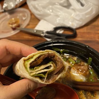Magic Noodle - a person holding a piece of food with chopsticks - Chinese Near Me - Scarborough, Ontario Magic Noodle - a person holding a piece of food with chopsticks - Chinese Near Me - Scarborough, Ontario