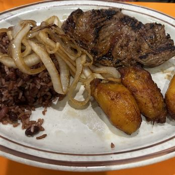 Cerro Negro - Bistec encebollado smothered with onions, black rice and bean, fried plantains - Latin American Near Me - Miami, Florida Cerro Negro - Bistec encebollado smothered with onions, black rice and bean, fried plantains - Latin American Near Me - Miami, Florida