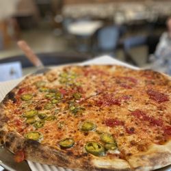 Sicily's Pizzeria & Subs - Round pizza with jalapeños on half