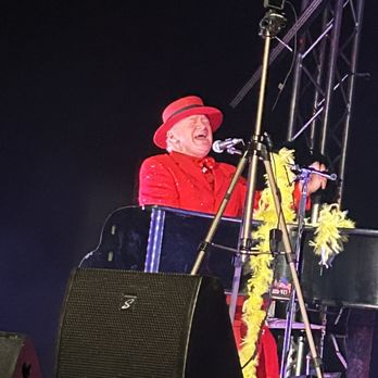 Geneva Stage - a man in a red suit and a red top hat singing into a microphone - Music Venues Near Me - Lake Geneva, Wisconsin Geneva Stage - a man in a red suit and a red top hat singing into a microphone - Music Venues Near Me - Lake Geneva, Wisconsin