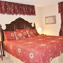 Die Heimat Country Inn - Room 11 King room with deep burgundy and tan decor, romantic fireplace and loveseat.