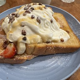TWISTED BLISS  HOUSE MADE CHALLAH BREAD, FRENCH TOAST BATTER, BANANA, STRAWBERRIES, RUM SAUCE, WALNUTS, AND SYRUP.