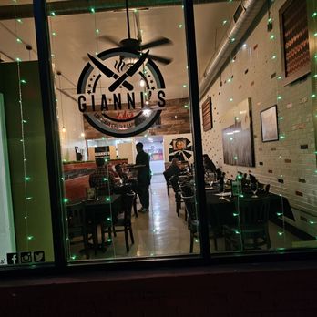 Gianni's Restaurant - The front window of the restaurant with the logo and bright green lights hanging. - Caribbean Near Me - Roanoke, Virginia