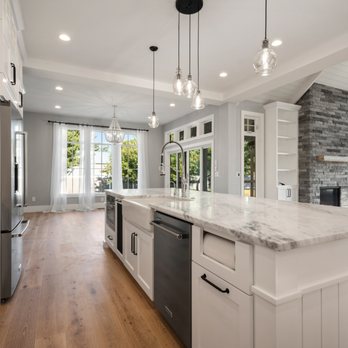 Creekside Construction - a kitchen with white cabinets and a marble island - General Contractors Near Me - Hayden, Idaho Creekside Construction - a kitchen with white cabinets and a marble island - General Contractors Near Me - Hayden, Idaho