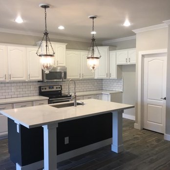 Lollis Custom Interiors - Kitchen post remodel.  Painted cabinets, new quartz counters, extended island, new lighting, crown molding. - General Contractors Near Me