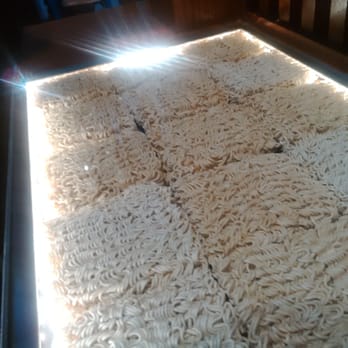 Ippudo London - the counter of the bar is lined inside with ramen - Ramen Near Me - London, XGL