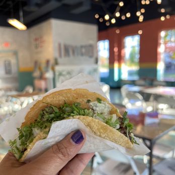 Invicto - a hand holding a taco in a restaurant - Mexican Near Me - Naperville, Illinois Invicto - a hand holding a taco in a restaurant - Mexican Near Me - Naperville, Illinois
