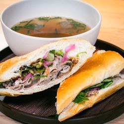 LUA Asian Fusion Eatery - Brisket Phở Dip: Brisket pho in a baguette: braised brisket, bean sprouts, picked onions, Thai basil, pickled red onion, hoisin, and Srirach