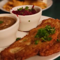 Polska Chata - Traditional potato pancakes served with hearty pork and gravy sauce, sourcream, and pickled beets.