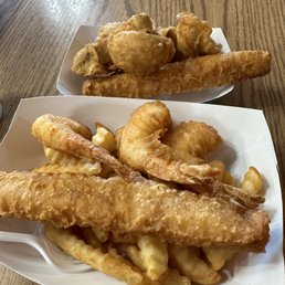 Fish, shrimp and chips in the forefront. Extra piece of fish and and fried mushrooms in the back. Fish, shrimp and chips in the forefront. Extra piece of fish and and fried mushrooms in the back.