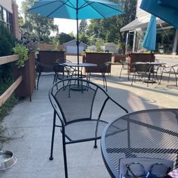 Outdoor dog friendly restaurant patio with flower boxes and 6 tables that seat 4 people, each table with an umbrella. Outdoor dog friendly restaurant patio with flower boxes and 6 tables that seat 4 people, each table with an umbrella.