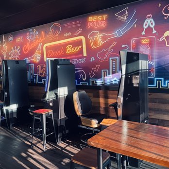 Cool Bar - a row of tables and chairs with neon signs on the wall - Sports Bars Near Me - Happy Valley, Oregon