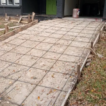 BHM Concrete - A concrete driveway is under construction, with wooden forms outlining the area and a grid of reinforcing steel bars in place... - Masonry/Concrete Near Me BHM Concrete - A concrete driveway is under construction, with wooden forms outlining the area and a grid of reinforcing steel bars in place... - Masonry/Concrete Near Me