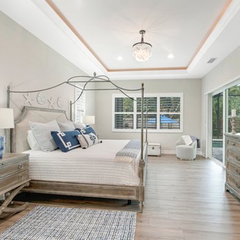 Caithness Construction - a bedroom with a bed, dressers, and a flat screen tv - General Contractors Near Me - Osprey, Florida