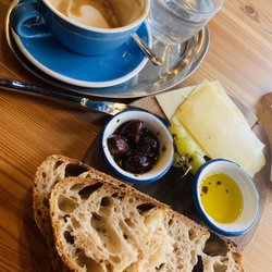 Brotklappe - Brot mit Olivenöl, Tiroler Käse, Kalamata-Oliven und Café-Latte