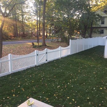 Great Escape - a white picketed fence in a backyard - Fences & Gates Near Me