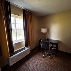Super 8 by Wyndham New Hampton - Chair. Table. Rug. Heater/AC. The window opens for a nice breeze. Very quiet area