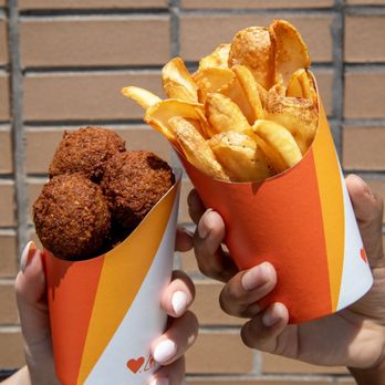 Naf Naf Grill - two hands holding a basket of fried food - Middle Eastern Near Me - Chicago, Illinois