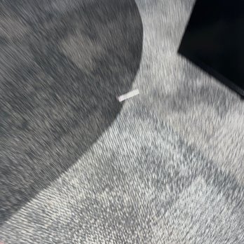 CVS Pharmacy - This is a used Covid test swab on the floor by the pharmacy counter - The image shows a used Covid test swab on a gray textured carpet. The swab is small, with a white handle and a pink tip, positioned near the center of the image. A shadow is cast on the carpet, likely from an object outside the frame. A black object, possibly a piece of electronic equipment, is partially visible in the upper right corner. The scene appears to be indoors, on a carpeted floor. - Drugstores Near Me - Riverside, California