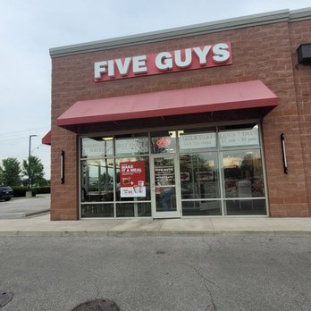 Five Guys - Exterior view of a Five Guys restaurant with glass entrance doors, signage, and a red awning, located in a commercial area. - Burgers Near Me - Dublin, Ohio