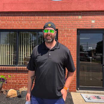 Four Dogs Distilling - a man standing in front of a building - Distilleries Near Me - Akron, Ohio