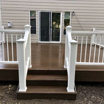 Value Landscape - a deck with white railings - Landscaping Near Me