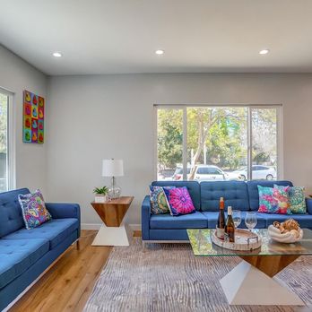 Coleman Construction - a living room with blue couches and a glass coffee table - General Contractors Near Me - Los Angeles, California Coleman Construction - a living room with blue couches and a glass coffee table - General Contractors Near Me - Los Angeles, California