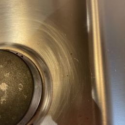 more scratches - A stainless steel kitchen sink shows scratches and some dirt or debris at the bottom, with a clean, reflective surface.