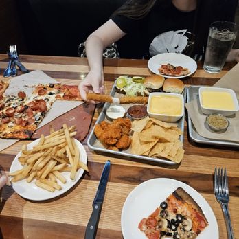 BJ's Restaurant & Brewhouse - Pizza, starter platter with sliders, buffalo wings, nachos a side of fries and a pretzel - Pizza Near Me - Folsom, California