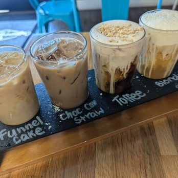 Caffeine Machine - Coffee flight left to right: funnel cake latte, chocolate covered strawberry mocha, toffee cold brew, and blondie cold brew. - Coffee & Tea Near Me - Las Vegas, Nevada