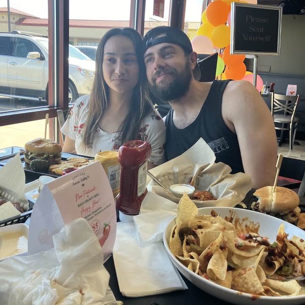 Wild Chicken Grill - Kenny and Mariella enjoying their burgers and nachos - Bars Near Me - Bellevue, Nebraska