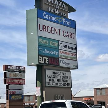Hi BoBa - a truck parked in front of a large sign - The image features a tall outdoor sign with multiple business advertisements in Albuquerque, NM. The sign includes names such as 'Cosmo Prof,' 'Urgent Care,' 'Pearle Vision,' 'Hi Boba,' 'Elite Nails,' and others. The sign is situated in a commercial area with several storefronts visible in the background, including furniture and food establishments. The sky is partly cloudy, and a white pickup truck is parked in front of the sign. - Bubble Tea Near Me - Albuquerque, New Mexico