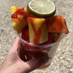 a hand holding a cup of fruit a hand holding a cup of fruit