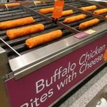 QuikTrip - More taquitos, can't remember what kind lol - Frozen buffalo chicken sticks are placed on a grill at a convenience store, with some sticks showing grill marks while others remain frozen. The grill is part of a retail setting, likely near food service areas, with a visible pink sign indicating the store offers various food options including buffalo chicken and cheese. - Gas Stations Near Me - Lindale, Texas