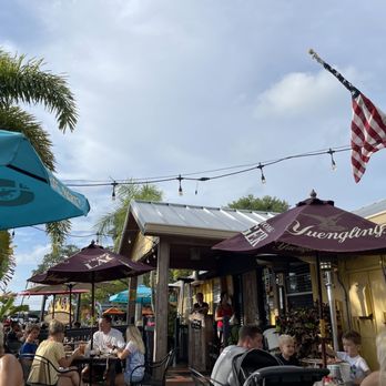 Fireside Pizza Cafe - people sitting outside under umbrellas - Pizza Near Me - Palm Harbor, Florida