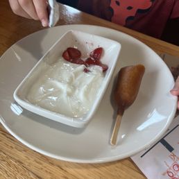 Kids corn dog and strawberries w yogurt.